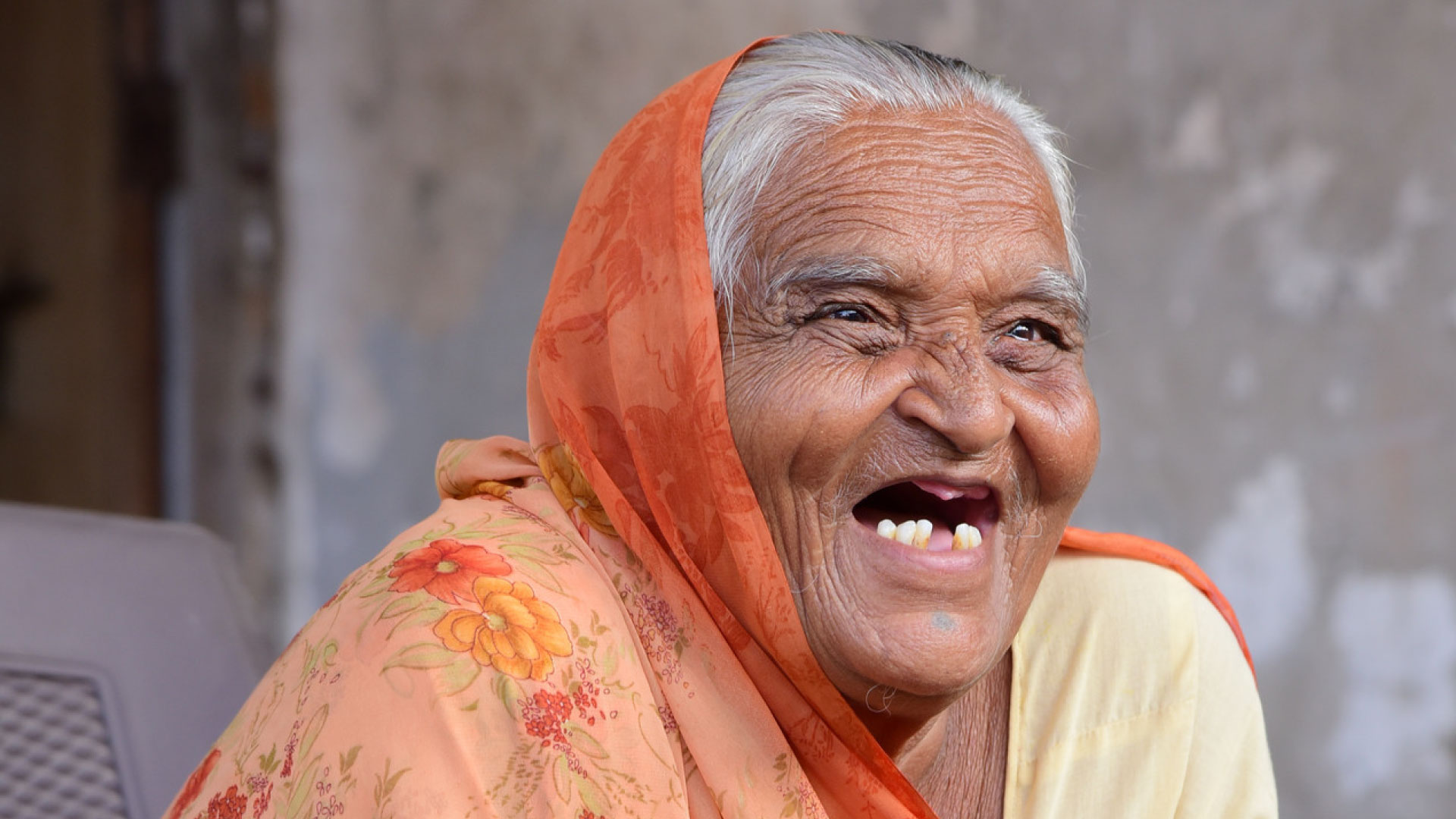 Haqdarshak Annual Impact Report 2023 — Intro Image of a happy and smiling elderly woman.